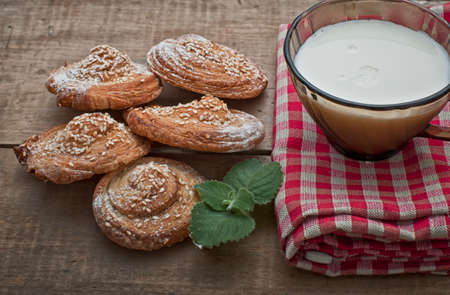 Festive sweets, puff cookies with sesame seeds and milk on gingham table clothの写真素材