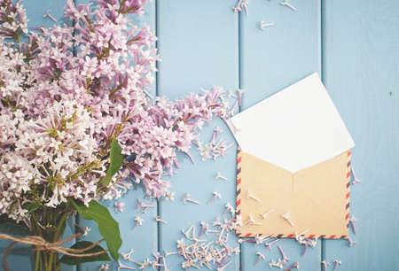 vintage postage envelope with card and beautiful summer blooming bouquet of lilacの写真素材