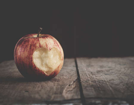 old grainy film shot with apple on wooden tableの写真素材