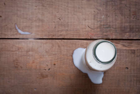 milk in glass bottle on wooden tableの写真素材