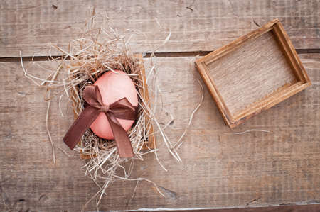 easter egg decorated with ribbon on wooden backgroundの写真素材