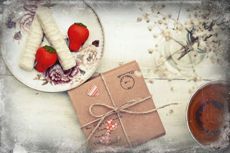 Spring still life with parcel, tea, marzipan and white chocolate sweets and dry bouquetの写真素材