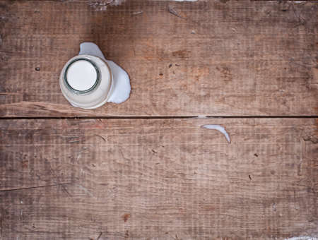 milk in glass bottle on wooden tableの写真素材