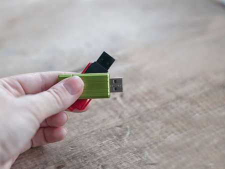 hand holding usb flash disks on wooden backgroundの写真素材