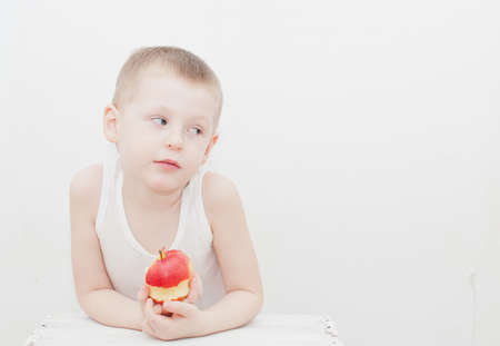 Boy eat apple on white backgroundの写真素材