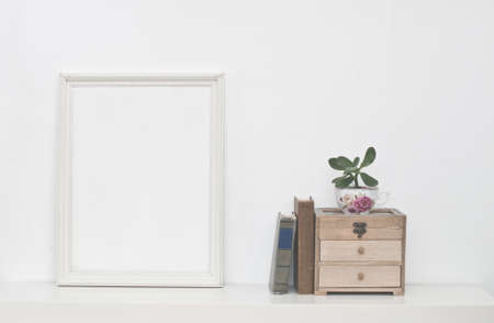 Empty picture frame and flowers on white wallの写真素材