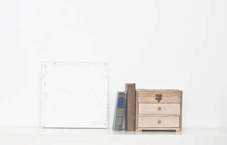 Old shabby canvas, books and box on white backgroundの写真素材