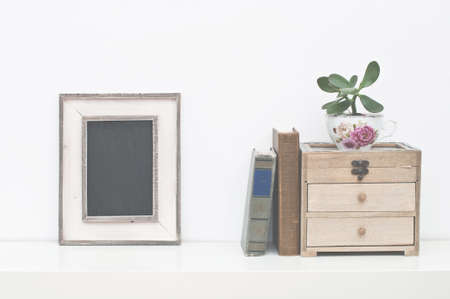 Empty picture frame, box, plant and vintage books on white backgroundの写真素材