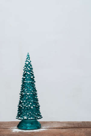 Decorative christmas tree with snow at vintage wooden table on white backgroundの写真素材