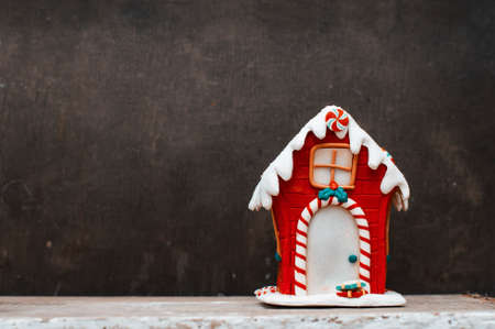 Red vintage christmas gingerbread house on the old brown backgroundの写真素材
