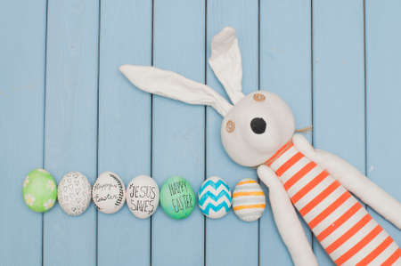 Easter bunny with decorated eggs on blue backgroundの写真素材