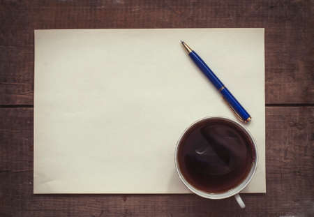 coffee, pen and blank paper on vintage wooden backgroundの写真素材