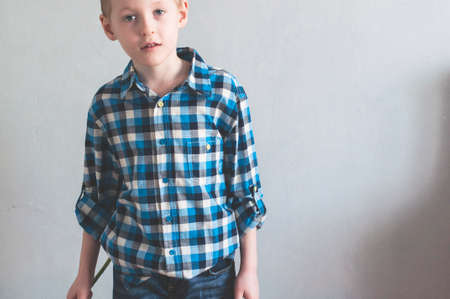 little serious boy is standing like a teacher with pointerの写真素材