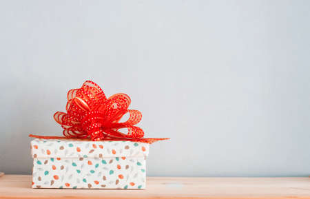 a craft gift box with red ribbon on the tableの写真素材
