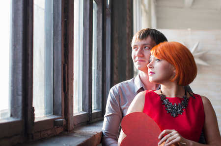 Happy dreaming family couple is looking in the windowの写真素材