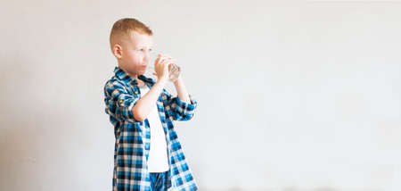 child drinks pure water from transparent glassの写真素材