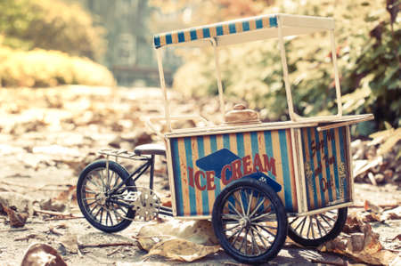 Vintage ice cream cart on wheels  in autumn park in sunny dayの写真素材