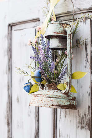 Vintage wedding decorative lantern with flowers on the doorの写真素材