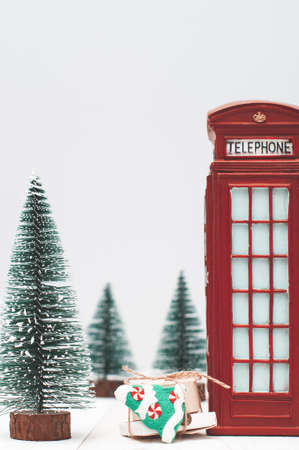 Toy London red phone booth, gifts and christmas trees on light winter backgroundの写真素材