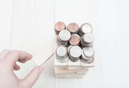 Human hand pulling wooden brick from the tower. Concept of planning, risk and strategy in businessの写真素材