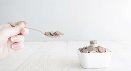 People eating money changes as dessert. Consumering concept.の写真素材