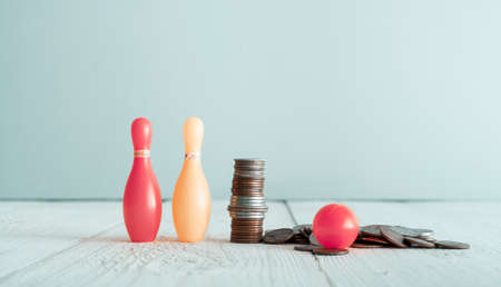 Bowling pins, ball and pile of american cents on the table in nursery roomの写真素材