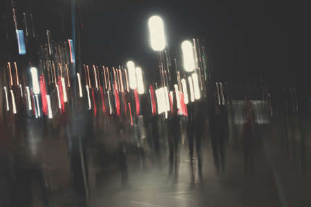 Abstract picture with defocused night street lights and people walking like ghostsの写真素材