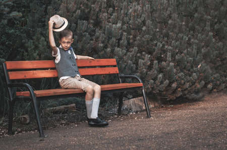 Retro portrait of child sitting at  the park bench in the countrysideの写真素材