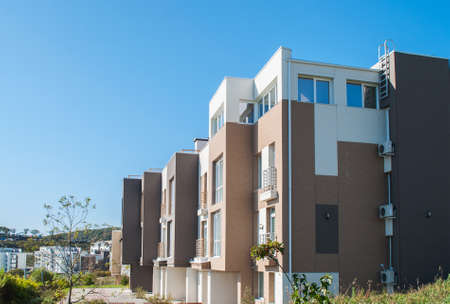 Modern minimalistic apartment building with brown door