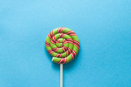 red and green swirl lollipop on blue backgroundの写真素材