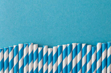 Monochrome swirled drinking straws on pastel blue backgroundの写真素材