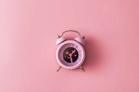 It's time for love management. Pink alarm with heart shape symbols on pink backgroundの写真素材