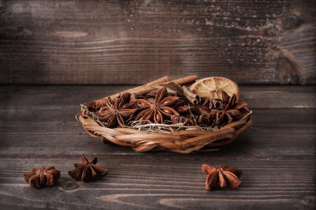 Anise stars, dried oranges, cinnamon sticks on rustic wooden tableの写真素材