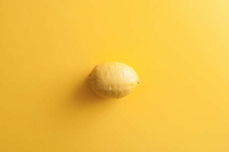 Fresh organic lemon on bright yellow background