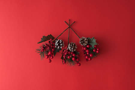 Merry christmas red background with fir tree branches. Greeting card. Winter holiday. Happy new year. Top view. Flat lay.の写真素材
