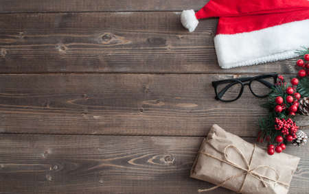 Santa Claus house flat lay with christmas gifts, red hat, glasses and decorations