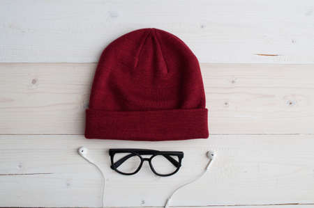 Crimson color winter hat, glasses and headphones on bright white backgroundの写真素材