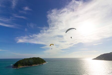 Two paragliders over the small islandの写真素材