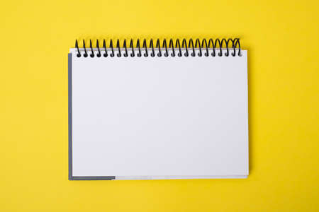 Blank notebook on yellow background.の写真素材