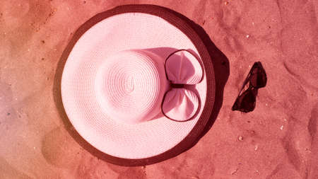 A woman's hat is lying on the sandy beach. A big  hat on a background of sand. near. Concept: vacation, travel, summerの写真素材