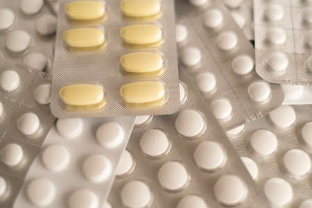 Tablets in blister packs. Close-up of yellow and white pills.