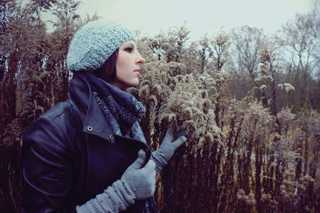 portrait of a girl in profile in a meadow autumn in hat and gloves