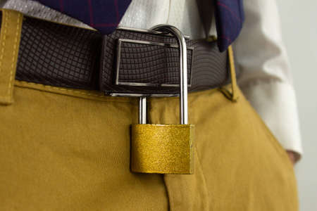 Padlock hanging from man's belt, symbol of marital fidelity, close upの写真素材