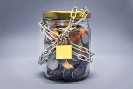 Jar full of coins locked with chain, savings conceptの写真素材