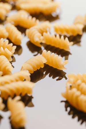 Dry Italian pasta on a dark mirror background.の写真素材