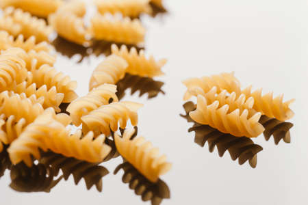 Dry Italian pasta on a dark mirror background.の写真素材