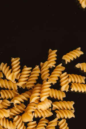 Dry Italian pasta on a dark background.
