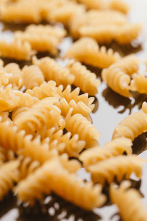 Dry Italian pasta on a dark mirror background.の写真素材