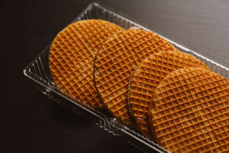 Wafer cookies with caramel in a transparent substrate on a black background.の写真素材