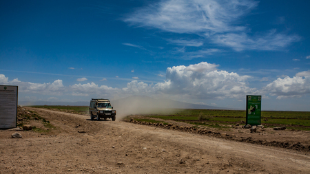 Big offroad car on the dusty road to safari in Serengeti national parkのeditorial素材